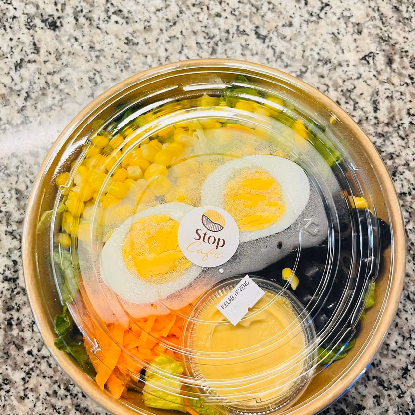 Ensalada sellada con huevo, choclo, zanahoria y aderezo.